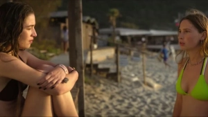 Adorazione 2024 beach tension scene in bikini featuring Penelope Raggi, natural outdoor lighting creates a warm Mediterranean atmosphere