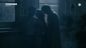 Partial nudity scene featuring three figures in an intimate embrace within a dark, moody interior setting from Dom Juan Sganarelle