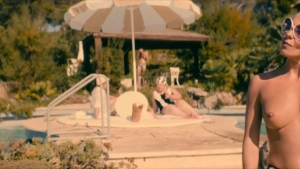 Jasmine Trinca nude poolside scene in Gli occhi degli altri 2025 - actress wearing bikini bottom, sunglasses and red headband standing in sunlight with photographer visible