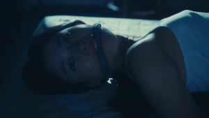 Cinematic close-up of Remi Miyamori lying down in a dimly lit, intimate setting from Like Love (Ai no Gotoku).