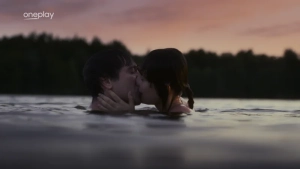 Tereza Voriskova and co-star share a passionate kiss in serene water setting. - img #1