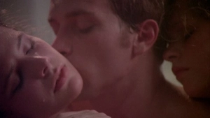 Intimate close-up of two individuals in Private Vices Public Pleasures 1976 with dim lighting focusing on their faces during a kiss.