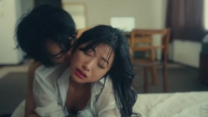 Close-up of Remi Miyamori and an intimate partner in a sensual embrace on a bed from the erotic film Like Love (Ai no Gotoku).