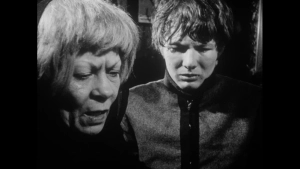 Vintage black-and-white close-up from Seeds of Sin (1968) capturing an intense, emotional profile moment between an older woman and a young man in a dimly lit interior.