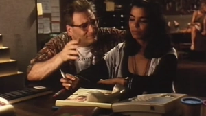 Kamala Lopez in an office setting from Erotique (1994)